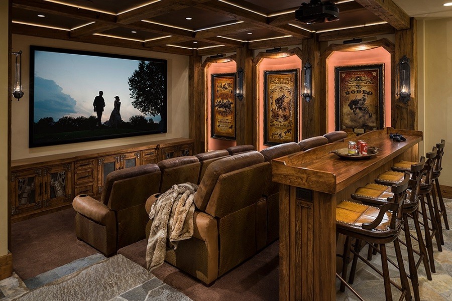 Classic home movie theater with antique movie posters, a bar for eating and driking, and luxury leather seats.