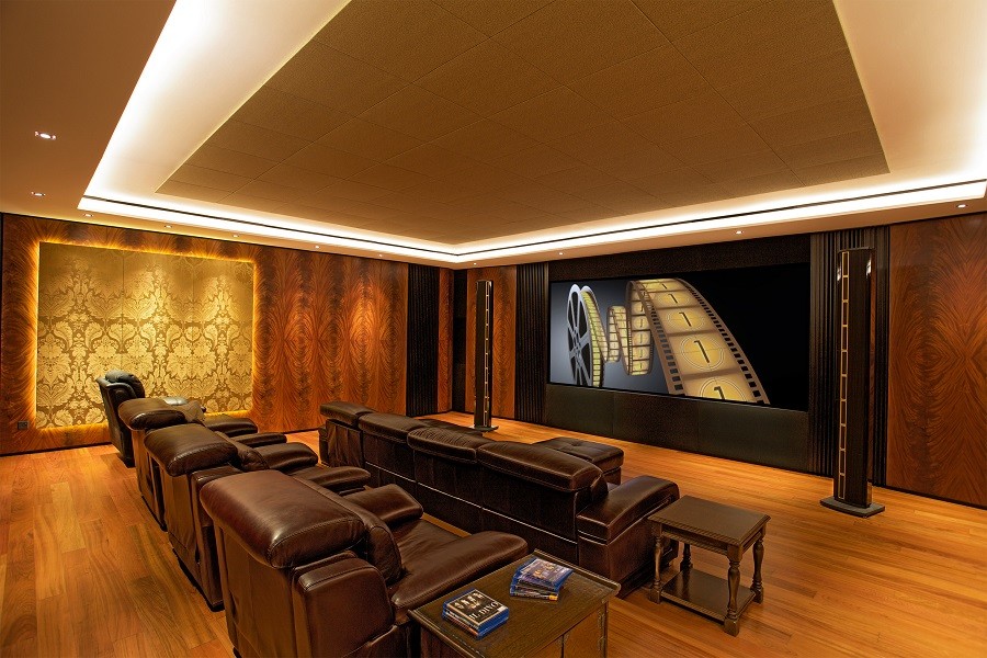 Home Theater with brown leather recliners looking at a screen with Steinway Lyngdorf speakers at the front. 
