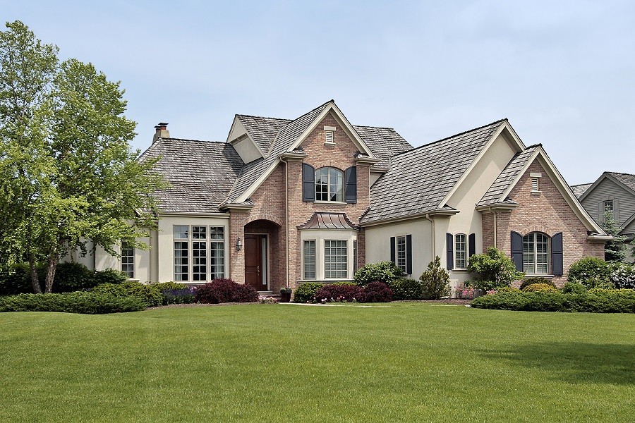 Large luxury home in the canterbury style with vibrant green lawn and 