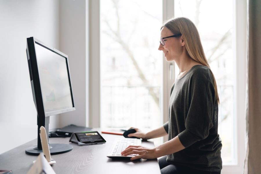 A woman sitting at a desk and working on a computer. 
