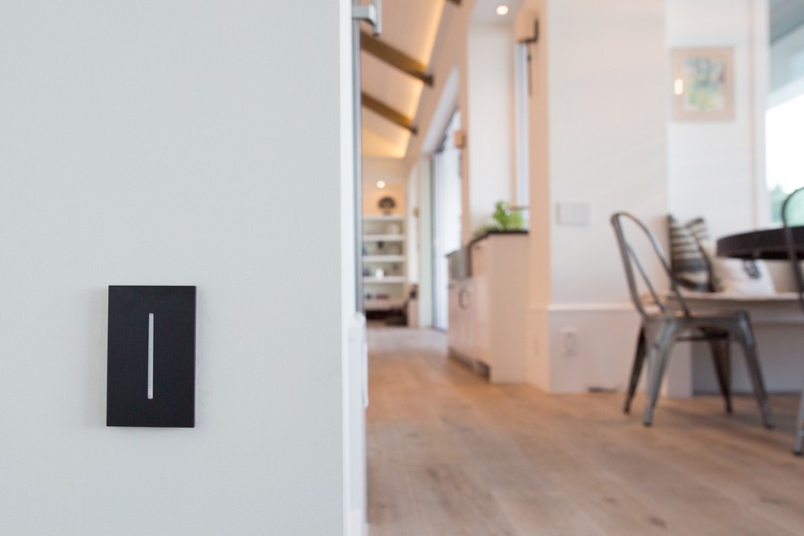 A closeup of an elegant lighting control keypad with a modern Colorado Springs living area in the background. 