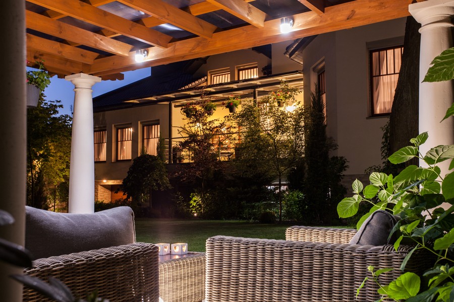 An inviting Denver backyard illuminated by outdoor lighting control, highlighting the patio area and garden for a warm, welcoming atmosphere.