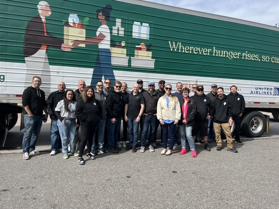 Group picture of the Aurum company in front of a community food pantry truck.